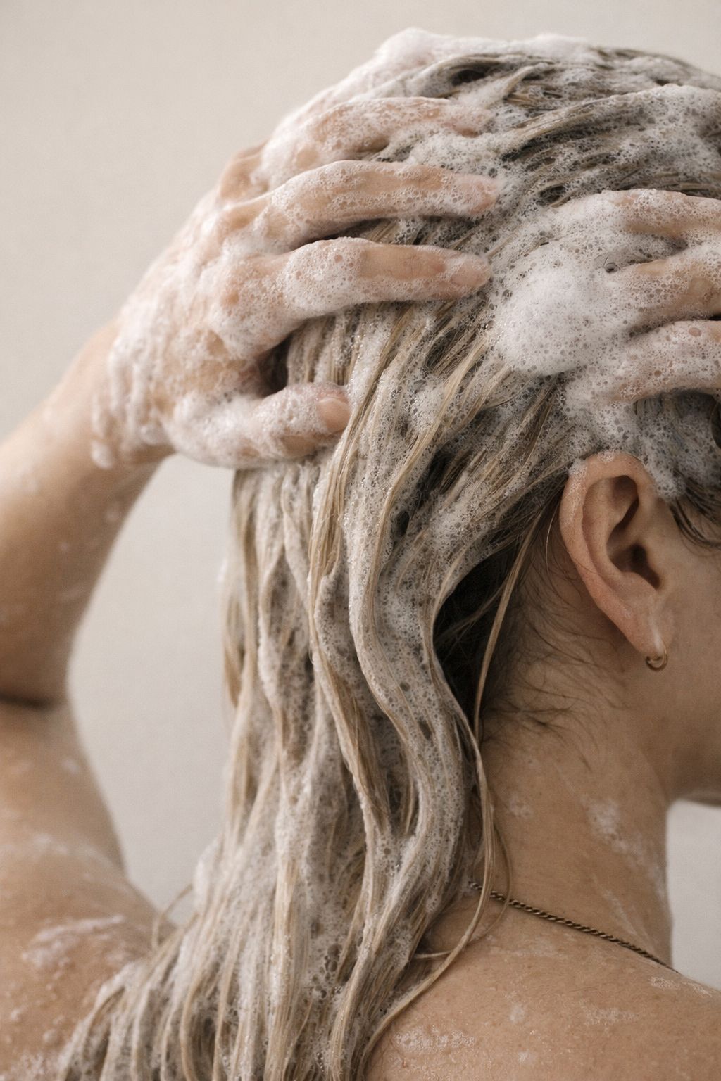 Cabelos cacheados sendo lavados com shampoo